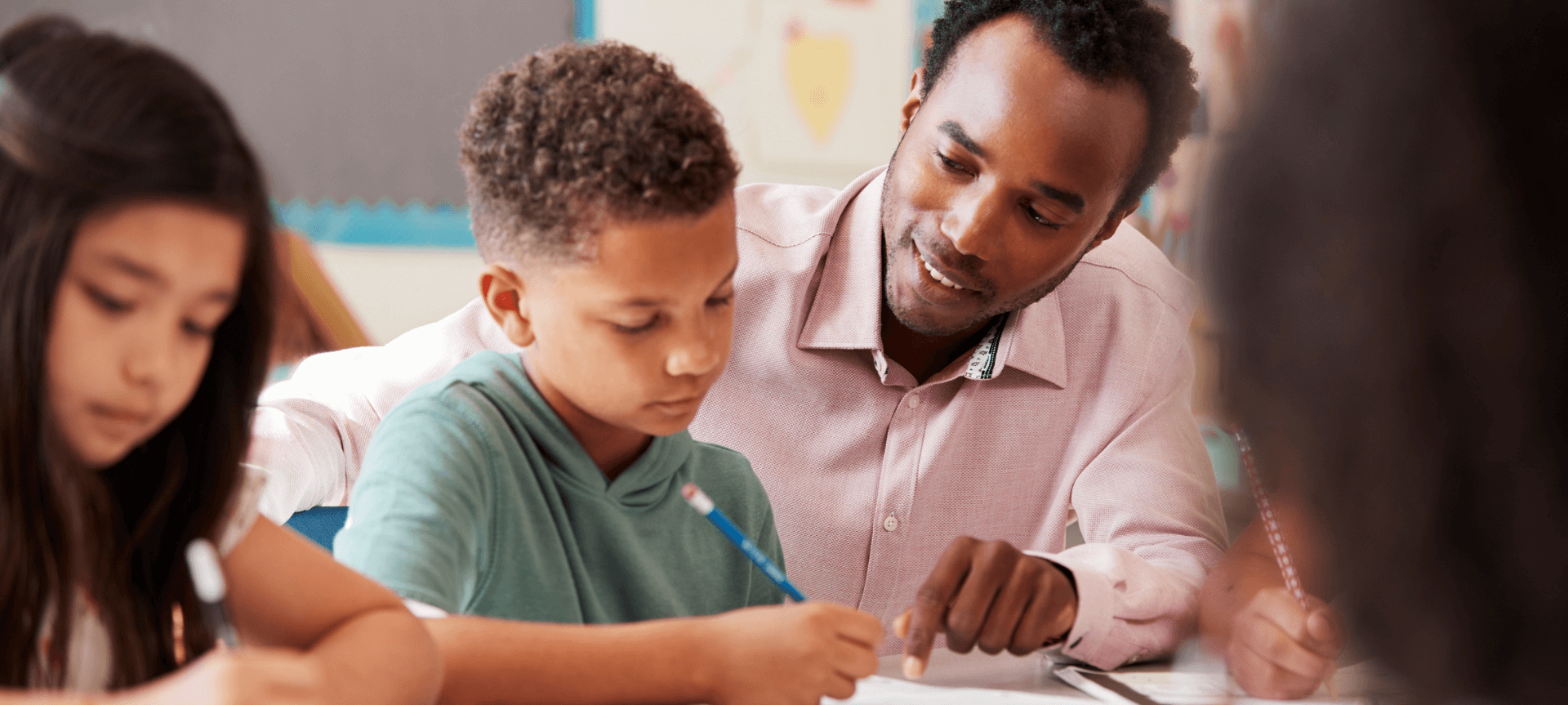 Male Teacher Working With Elementary Students