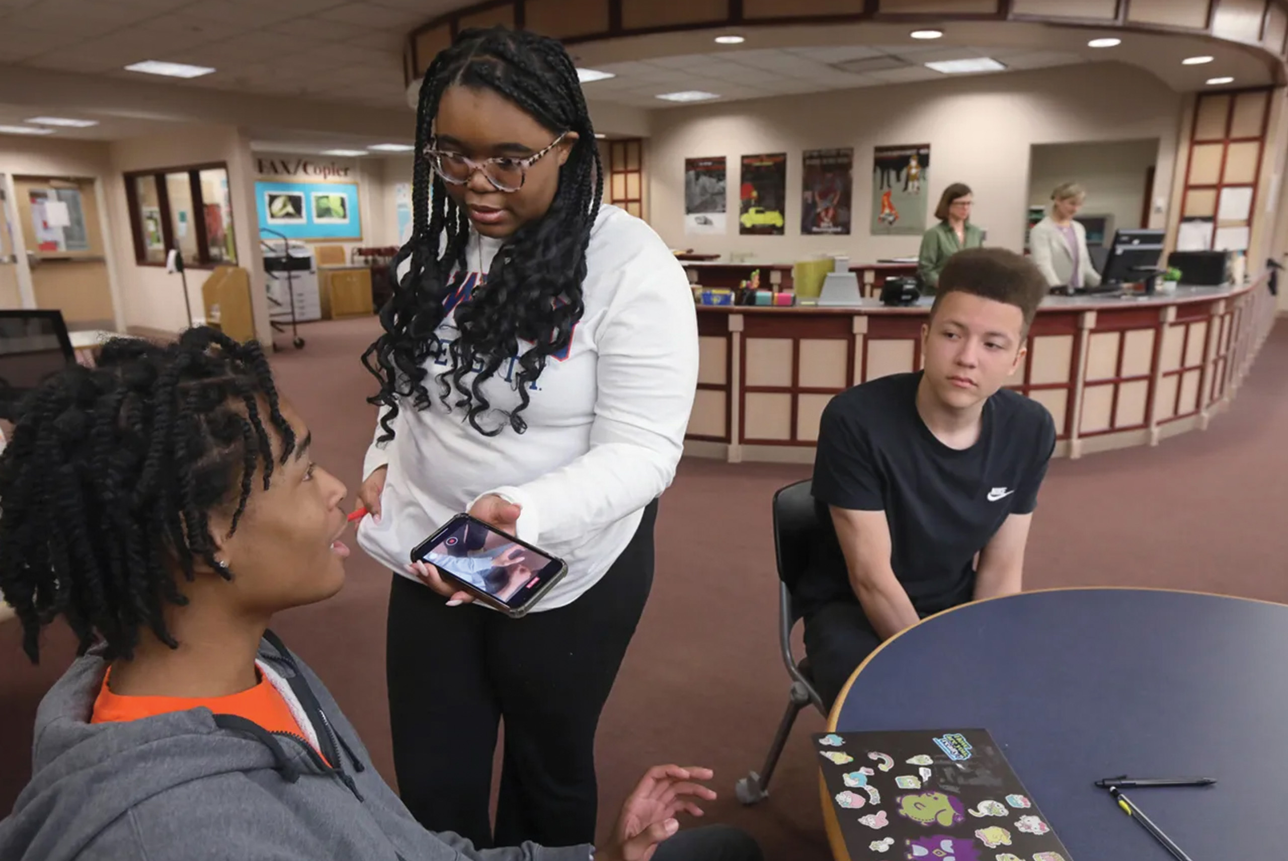 Student uses smart phone to interview other student.